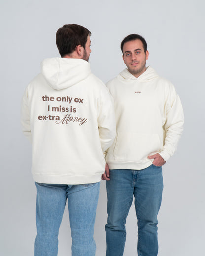 Dos chicos uno de cara otro de espaldas. Llevan la hoodie/sudadera beige con diseño en la espalda en marrón oscuro que dice "the only ex i miss is ex-tra money". La palabra money está resaltada con otra tipografía. Se ve también el logo de la marca bordado en marrón oscuro en el centro del pecho.