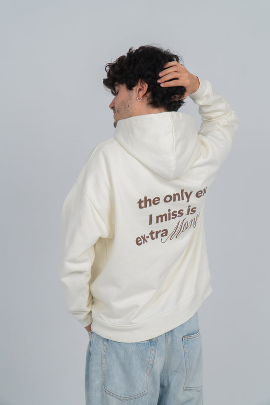 Chico lleva hoodie/sudadera beige con diseño en la espalda en marrón oscuro que dice "the only ex i miss is ex-tra money". La palabra money está resaltada con otra tipografía.